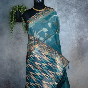 Teal blue tissue silk saree with floral leaf motifs, broad woven border and multicolour pallu