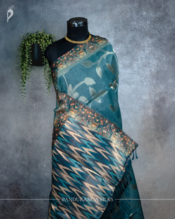 Teal Blue Tissue Silk Saree with Floral Motifs & Woven Pallu Teal blue tissue silk saree with floral leaf motifs, broad woven border and multicolour pallu