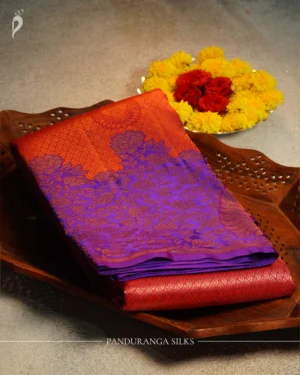 Coral pink pure silk saree with royal purple floral border, paisley buttas and traditional woven pallu