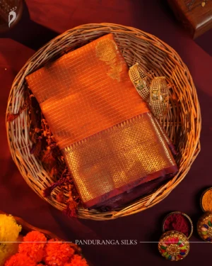 Burnt orange silk saree with zari checks, pineapple buttas, rich golden zari border and traditional pallu.