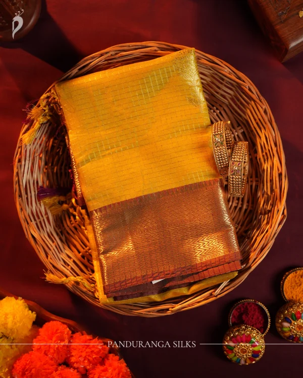 Mustard yellow silk saree with golden zari checks, pineapple motifs and geometric zari border