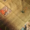 Sage Green Art Silk Saree with Mughal Art and Floral Emboss Work Sage green silk saree with Mughal-inspired printed panels, floral emboss work and zari border