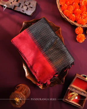 Charcoal black raw silk saree with zari checks, maroon temple-work border, contrast pallu and tassels