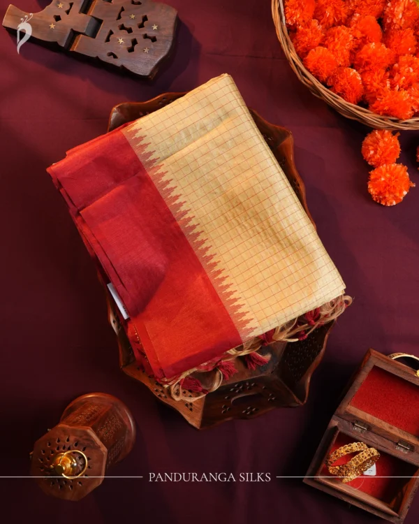 Ivory Raw Silk Saree with Checks and Deep Maroon Temple Border Ivory raw silk saree with zari checks, deep maroon temple border, contrasting pallu and tassel detailing