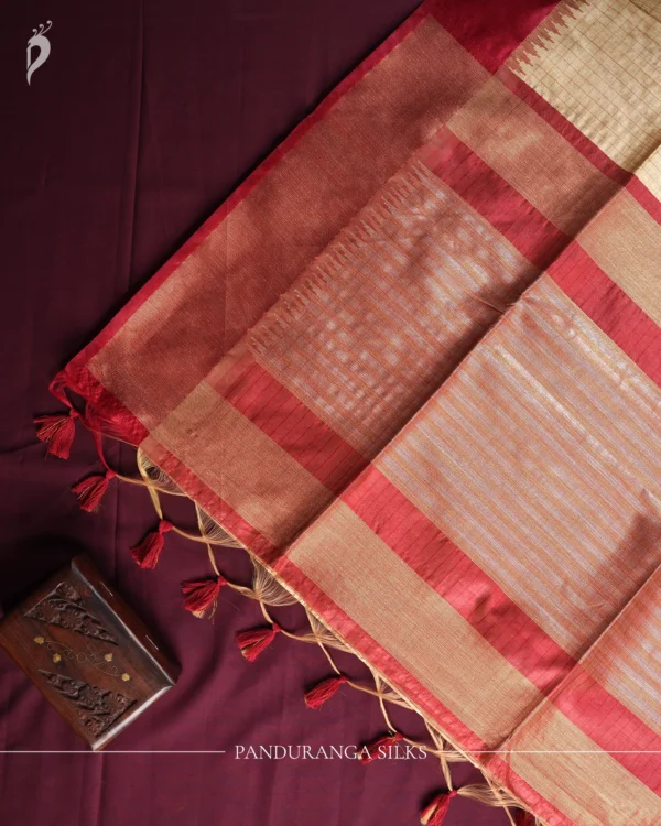 Ivory Raw Silk Saree with Checks and Deep Maroon Temple Border Ivory raw silk saree with zari checks, deep maroon temple border, contrasting pallu and tassel detailing