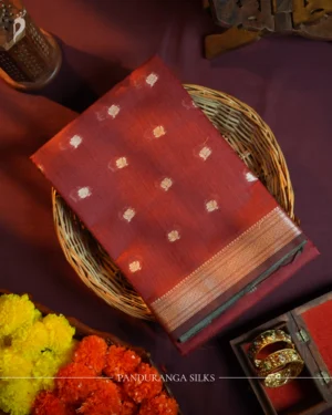 Maroon silk cotton saree with golden zari buttas and sage grey pallu