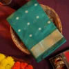 Peacock blue silk cotton saree with golden zari buttas and sage grey pallu and blouse