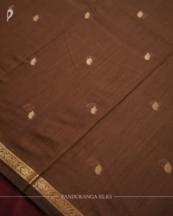 Brown Soft Silk Cotton Saree with Golden Zari Buttas and Purple Pallu Brown silk cotton saree with golden zari buttas and a purple pallu with zari border