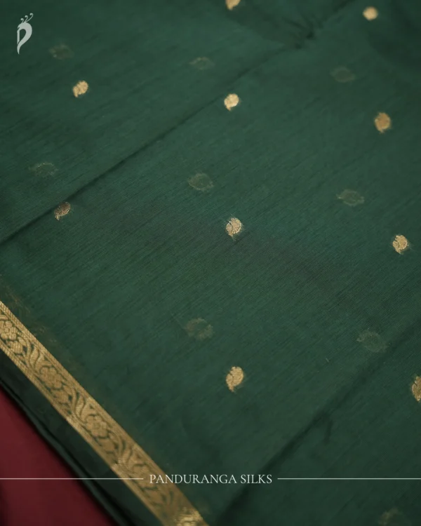 Dark Green Soft Silk Cotton Saree with Golden Zari Buttas Design Dark green silk cotton saree with golden zari buttas and detailed zari border