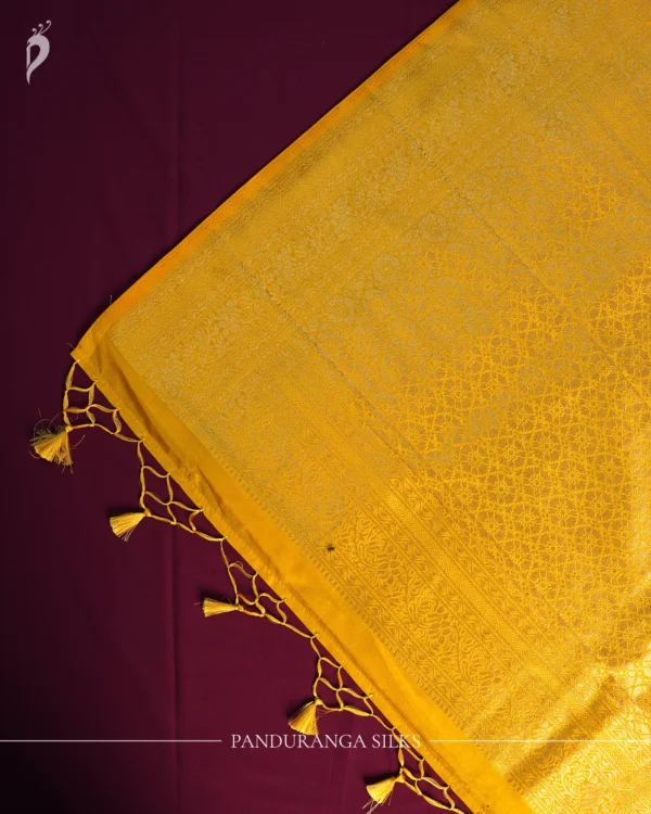 Lemon yellow georgette silk saree with floral zari buttas, golden zari border, floral motifs and tassel pallu