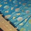 Turquoise Blue Georgette Silk Saree with Golden Floral Zari Work Turquoise blue georgette silk saree with floral zari buttas, golden zari border, teal shade and tassel pallu