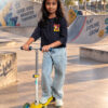 Blue crop T-shirt for girls with colourful front and back graphic prints, paired with light blue jeans.
