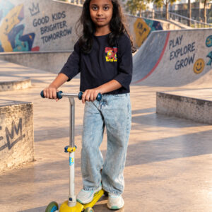 Blue crop T-shirt for girls with colourful front and back graphic prints, paired with light blue jeans.