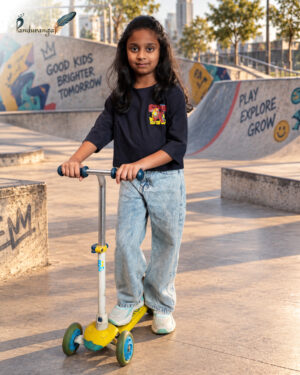 Blue crop T-shirt for girls with colourful front and back graphic prints, paired with light blue jeans.