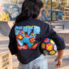 Blue crop T-shirt for girls with colourful front and back graphic prints, paired with light blue jeans.